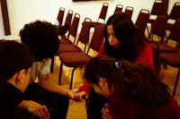 a girl is standing in front of a microphone and playing a keyboard